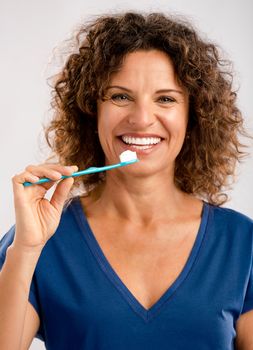 Beautiful mature woman brushing her teeths 