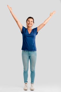 Portrait of a happy middle aged brunette with arms up