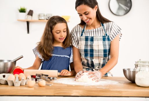 Shot of a mother and daughter having fun in the kitchen and learning to make a cake