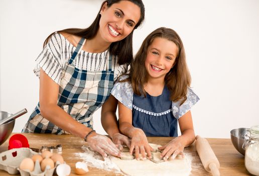 Shot of a mother and daughter having fun in the kitchen and learning to make a cake