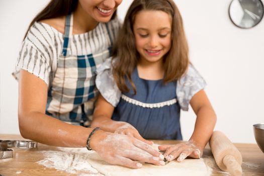 Shot of a mother and daughter having fun in the kitchen and learning to make a cake