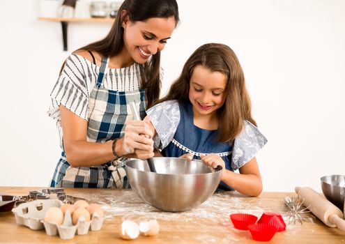 Shot of a mother and daughter having fun in the kitchen and learning to make a cake