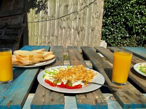 Tasty breakfast in the garden. Fresh eggs with cheese, bread and orange juice.