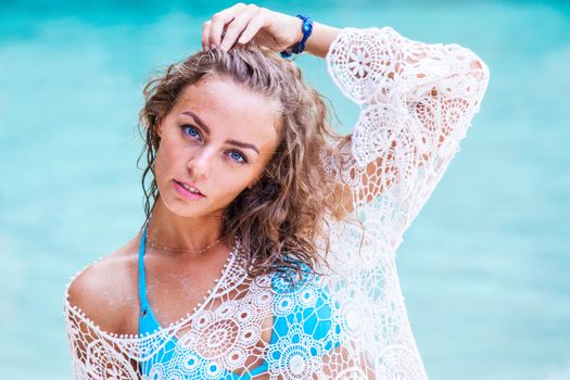 Beautiful young woman in bikini posing at sea beach