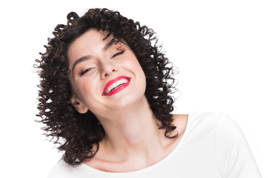 Portrait of amazing beautiful smiling woman with curly hair on gray background with copy space
