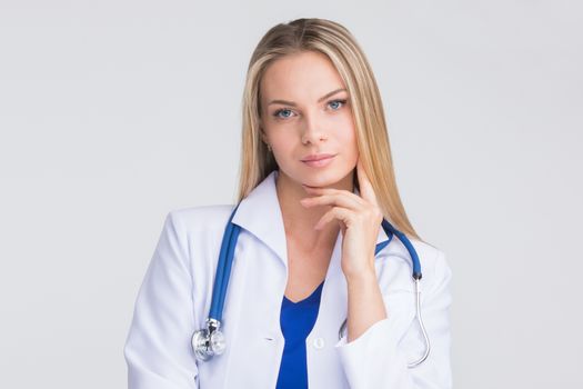 Close-up portrait of a beautiful thoughtful female doctor on gray background