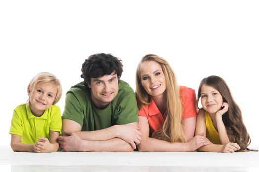 Casual family in colorful clothes lying on the floor isolated on white background