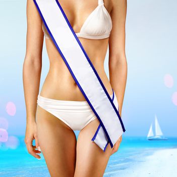 woman with white tape of beauty contest on beach