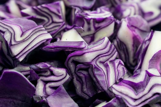 A portion of a red cabbage disposed on a white background