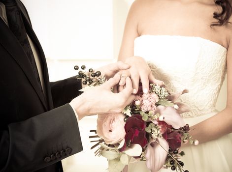 Groom places the wedding ring on the bride's finger