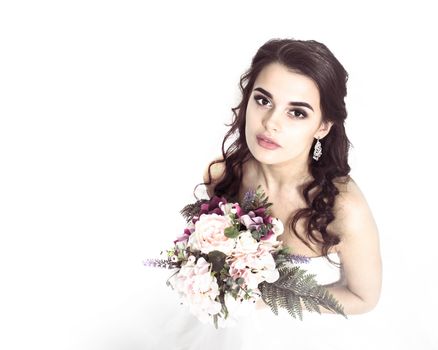 Beautiful bride posing in her wedding day with flower bouquet