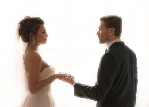 Young married couple holding hands, ceremony wedding day