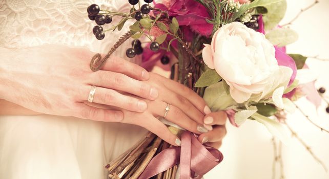 Beautiful wedding bouquet in bride's and groom's hands close up view