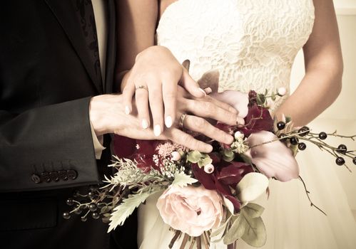 Beautiful wedding bouquet in bride's and groom's hands close up view