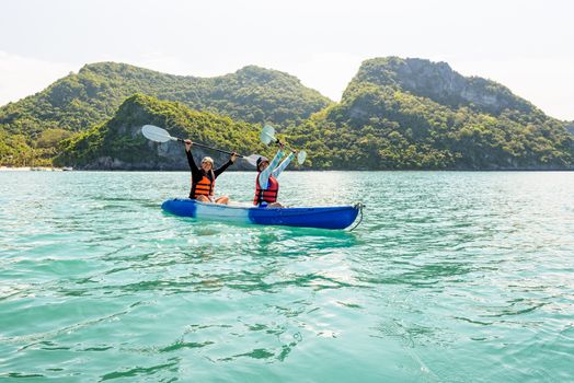 Two women are mother and daughter. Travel by boat with a kayak happy on the sea under the bright summer sky front of Ko Wua Ta lap islands at Mu Ko Ang Thong National Park, Surat Thani, Thailand