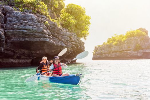 Two women are mother and daughter. Travel by boat with a kayak on the sea under sunlight at summer around Ko Phi enjoy the beautiful nature of the sea and island, Mu Ko Ang Thong National Park, Surat Thani, Thailand