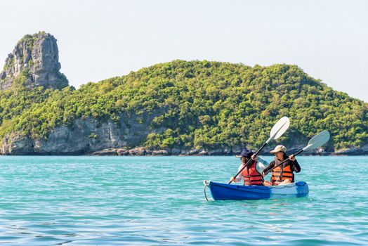 Two women are mother and daughter. Happy family travel by kayak around Ko Mae Ko view the beautiful nature of the sea and island during summer at Mu Ko Ang Thong National Park, Surat Thani, Thailand