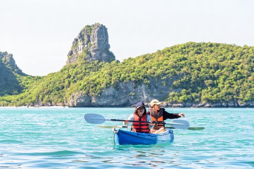 Two women are mother and daughter. Happy family travel by kayak around Ko Mae Ko view the beautiful nature of the sea and island during summer at Mu Ko Ang Thong National Park, Surat Thani, Thailand