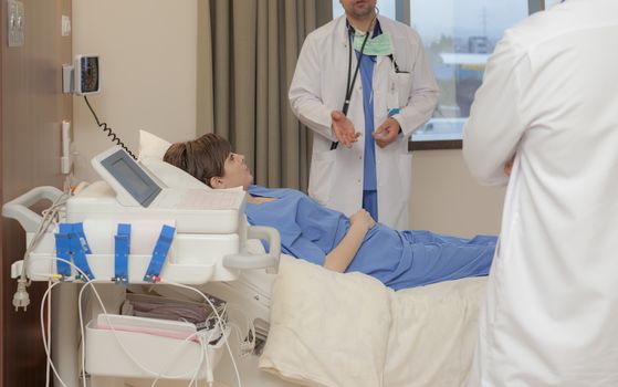 A patient is listening to a doctor, hand and torso only, in modern hospital.