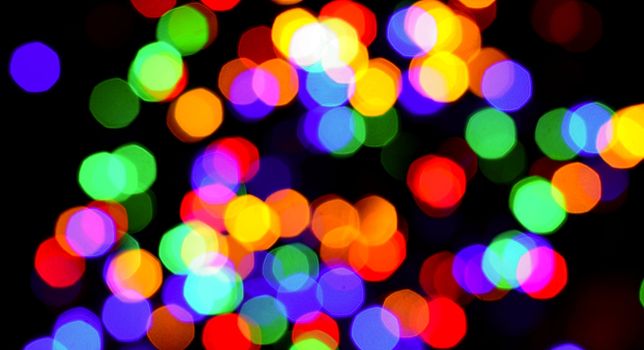 Colorful blurred bokeh lights on black background.