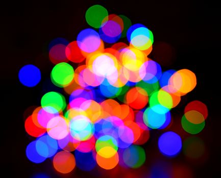 Colorful blurred bokeh lights on black background.