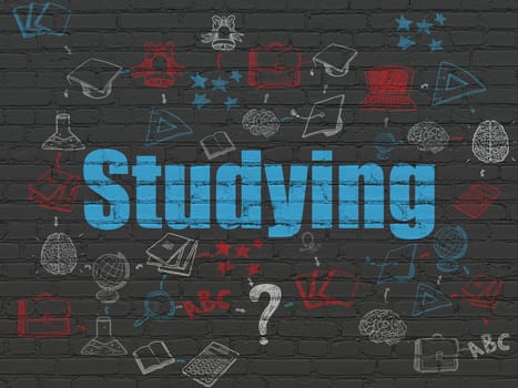 Studying concept: Painted blue text Studying on Black Brick wall background with Scheme Of Hand Drawn Education Icons