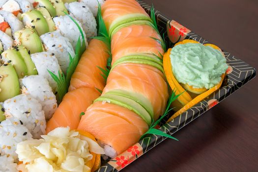 Sushi Party Platter with fresh raw salmon California Caterpillar rolls Nigiri Wasabi ginger closeup