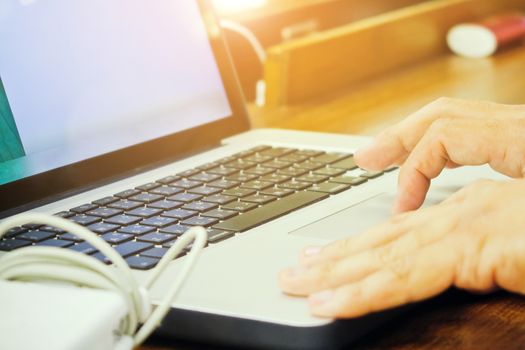 Close-up of female hands using laptop computer, working on laptop with flare light background. Searching Internet ,Social Networking Concept