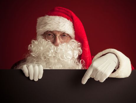 Santa Claus holding black paper billboard with copy space for text