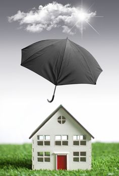 Umbrella protecting a house from bad weather