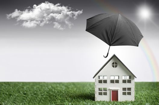 Umbrella protecting a house from bad weather with background space