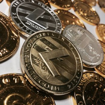 Digital currency physical metal litecoin coin near bitcoin coins. Money concept.