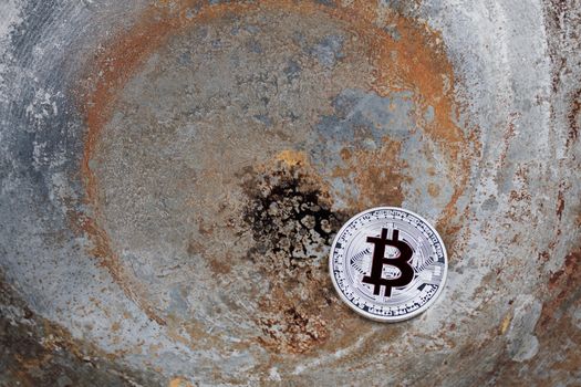 Crypto currency physical metal silver bitcoin coin on dirty scene.