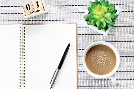 Business, weekend, holiday or new year planning concept : Top view or flat lay of open notebook paper, cube calendar and coffee cup on table background, ready for adding or mock up