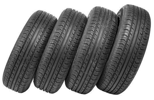 Stack of four wheel new black tyres isolated on white background