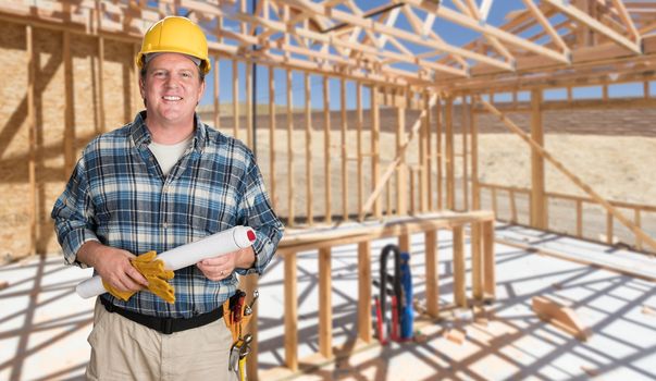 Male Contractor With House Plans Wearing Hard Hat Inside New House Construction Framing