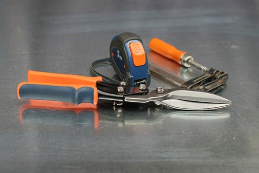 Scissors for metal, tape measure and clamp, metalwork tools