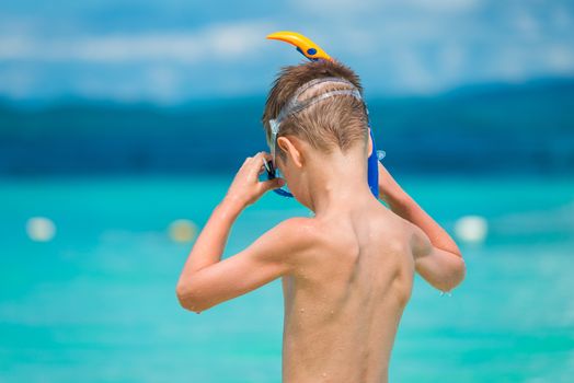 child wears a snorkeling mask on the seashore in the tropics