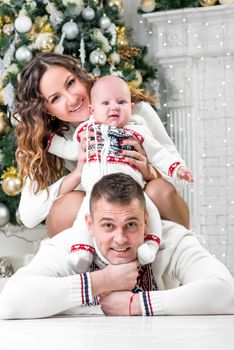 happy young family with son near Christmas fir-tree pose