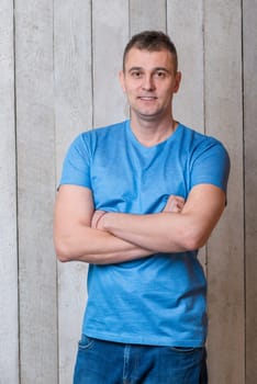 portrait of a man in a blue T-shirt on a wooden background close-up