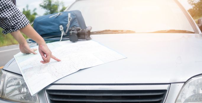 Hipster Asian woman backpacker look map on trip