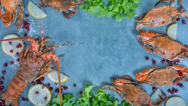 Food frame with crustacean . Lobster, crab, lemon and  pomegranate on background