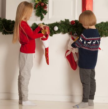 Adorable little children open their stocking gifts on Christmas morning