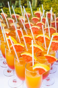 Orange juice cocktail in a flute glasses and slice of fresh orange with draw on white table,closed picture.