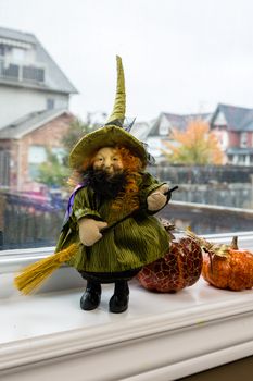 A witch figurine and two pumpkins adorned the window sill