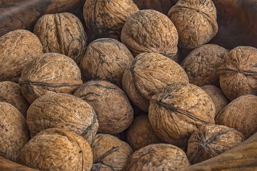 Lots of walnuts in wooden bowl. Close