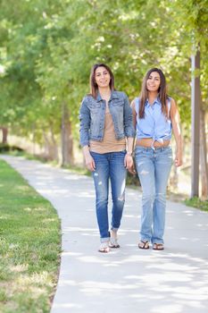 Two Beautiful Ethnic Twin Sisters Walking Outdoors.