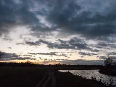 dramatic sun set night sky countryside side of river; essex; england; uk