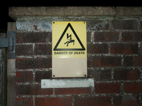 outside yellow danger of death warning sign wall; essex; england; uk