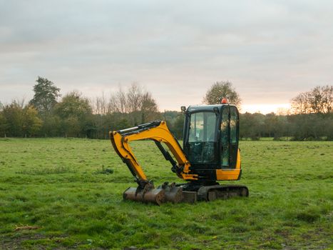 industry construction environment yellow digger machine parked outside country autumn; essex; england; uk